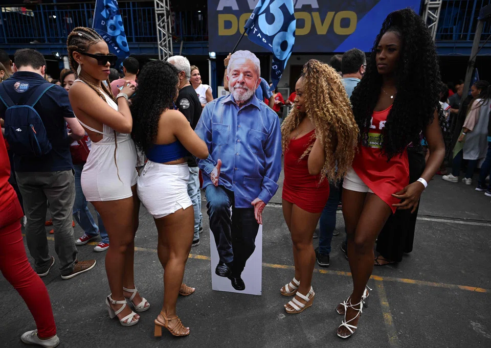 Supporters of the Brazilian presidential candidate for the leftist workers party (PT) and former President (2003-2010), Luiz Inacio Lula da Silva, gather around a cardboard cut-out of him during a rally at a school in Rio de Janeiro, Brazil on September 25, 2022. 