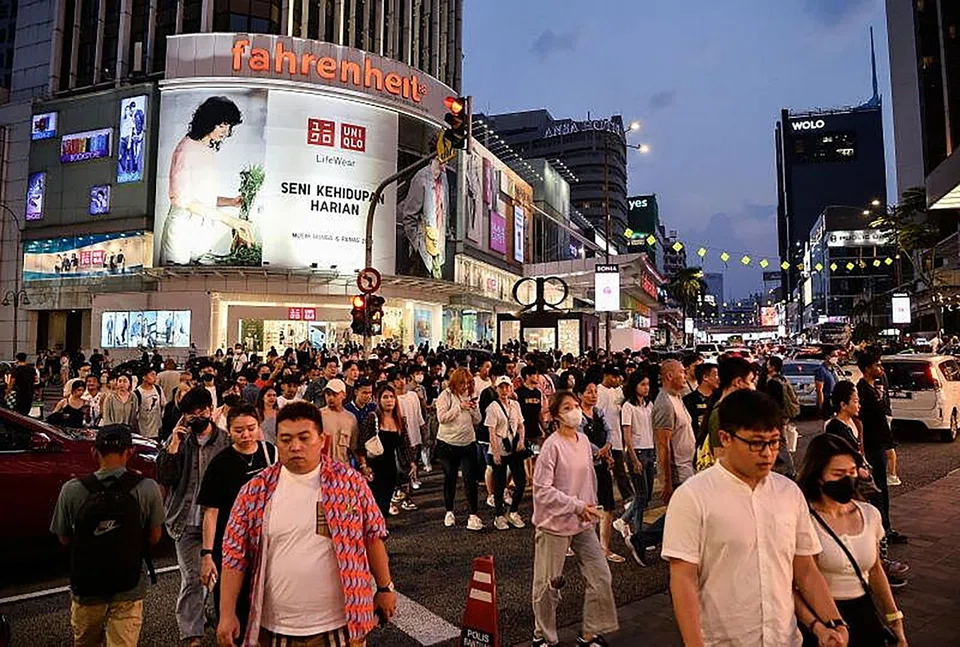 Pedestrians stroll around the tourist hotspots in Kuala Lumpur. Malaysia is set to raise its sales and services tax at the start of 2024.