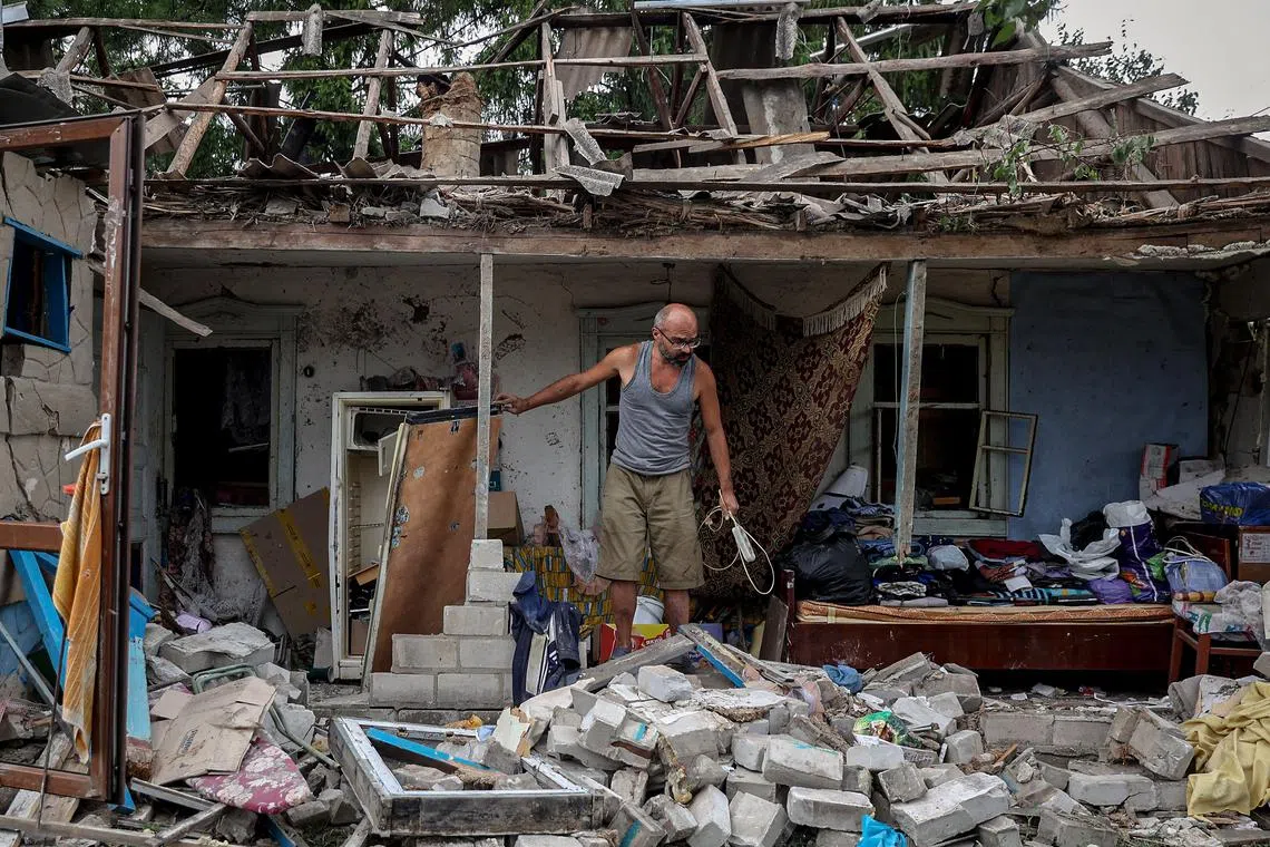 A local resident collects belongings from his destroyed house after a night missile strike in the town of Kramatorsk, in Donetsk region, on August 16, 2022, amid the Russian military invasion of Ukraine. 