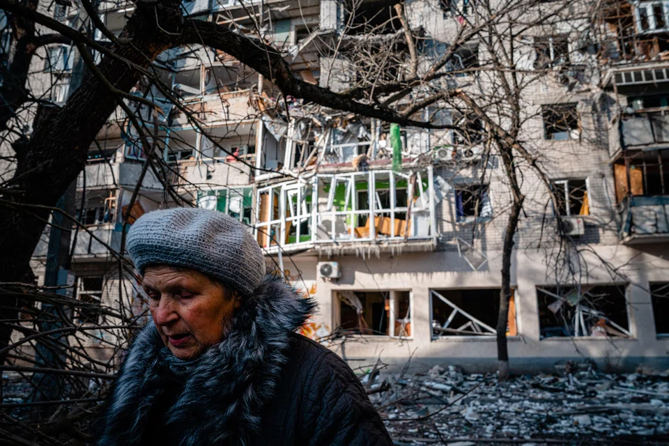 A pedestrian walks past a residential building damaged by Russian shelling in Kherson on Dec 20, 2022, amid the Russian invasion of Ukraine.