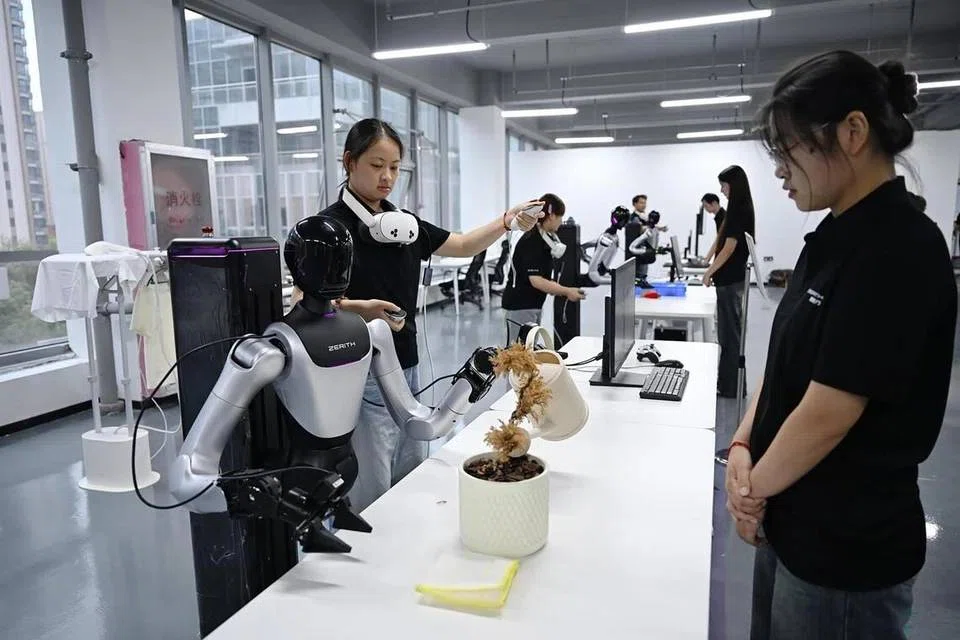 A human operator gets a humanoid robot to water a potted plant at robotics start-up Zerith's data collection facility in Hefei. 