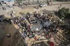Palestinians search for survivors in the rubble of a residential building, in Khan Younis refugee camp in the southern Gaza Strip, on Oct 16.  