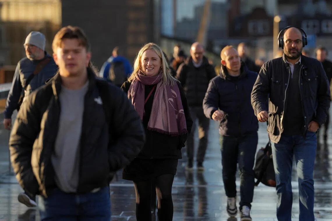 People walk across London Bridge during morning commute rush, in London, Britain, Jan 16, 2026. 