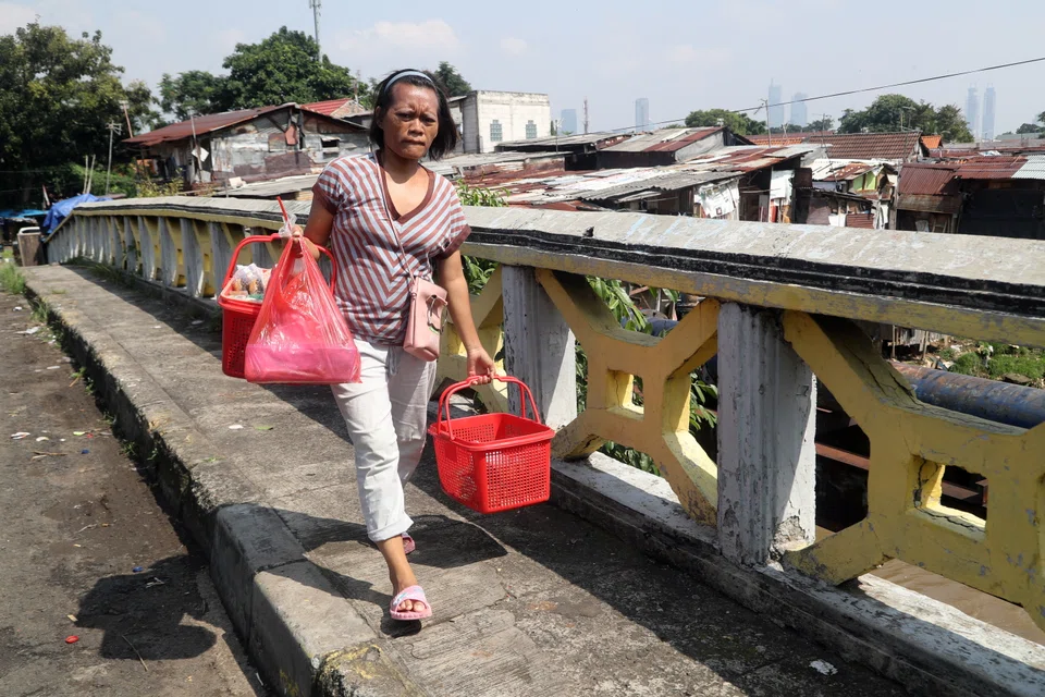 epa10037721 An Indonesian cake seller in a slum area in Jakarta, Indonesia, June 2022. According to the World Bank, the Covid-19 pandemic has affected Indonesia's poverty reduction progress, causing the poverty rate to rise from 9.2 per cent in September 2019 to 9.7 per cent in September 2021.  EPA-EFE/Bagus Indahono