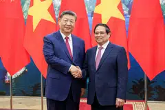 Vietnamese Prime Minister Pham Minh Chinh (right) and Chinese President Xi Jinping shake hands at the Office of the Party Central Committee in Hanoi, Vietnam on Apr 14.