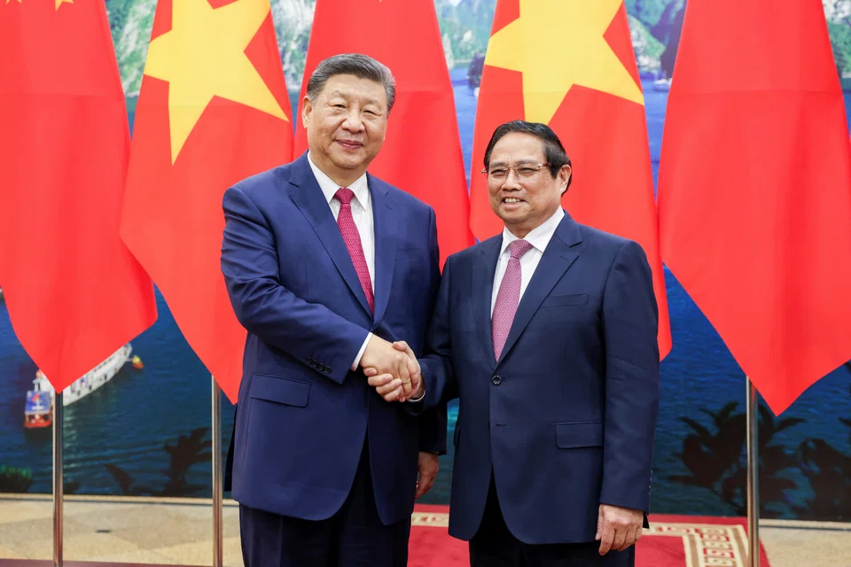 Vietnamese Prime Minister Pham Minh Chinh (right) and Chinese President Xi Jinping shake hands at the Office of the Party Central Committee in Hanoi, Vietnam on Apr 14.