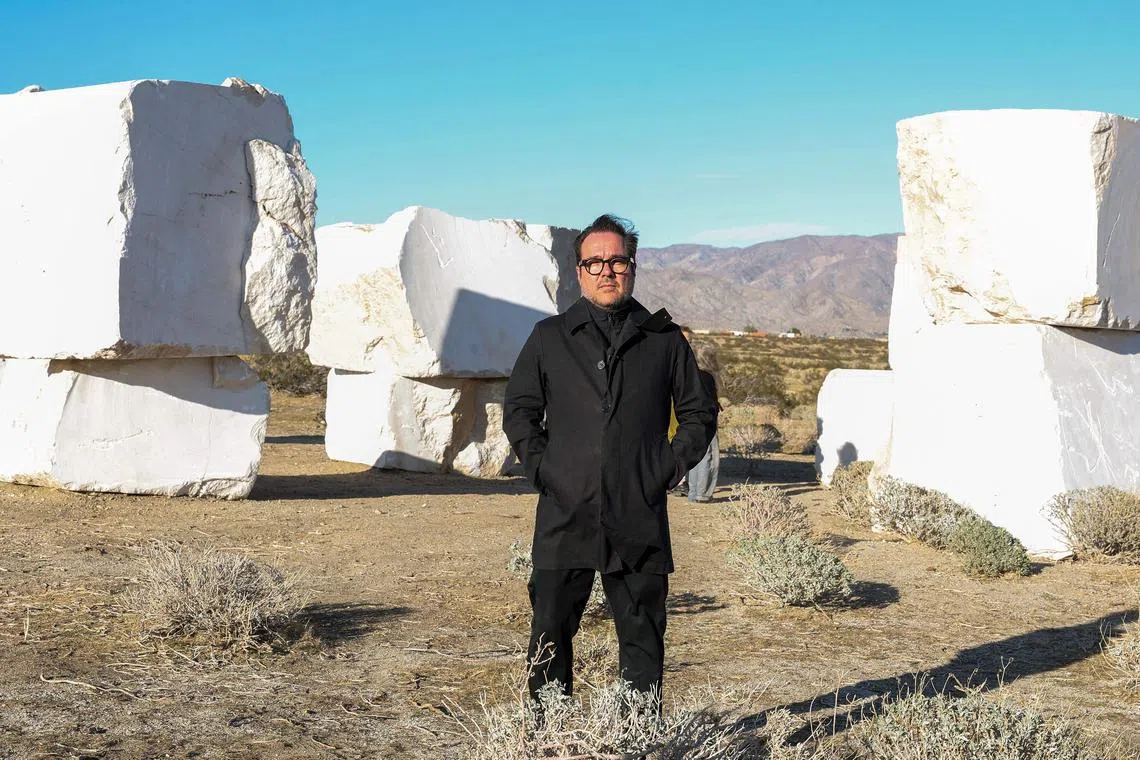 Mexican artist Jose Davila with his piece “The Act of Being Together”, which stacked colossal 16-tonne marble boulders that were quarried in the Chihuahua Desert of his nearby home country. .