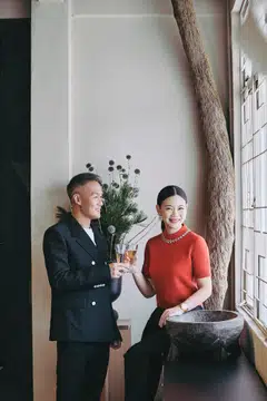 Tjin Lee wears a red knitted top, black wool trousers and Escale watch. John Lim wears a cream cotton T-shirt, black wool double-breasted suit and Escale watch. All by Louis Vuitton.