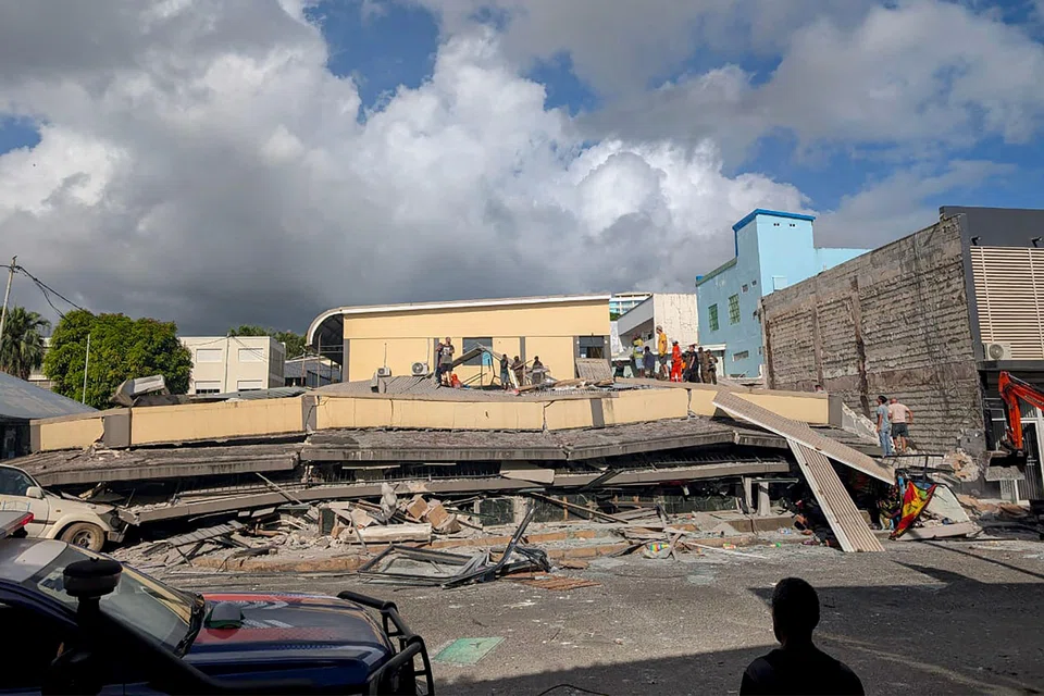 Rescue workers are seen at the site of a collapsed building after a powerful earthquake struck Port Vila, the capital city of Vanuatu.