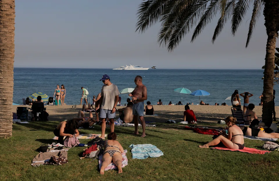 Tourists enjoying the weather at Malagueta beach, on a hot summer day, in Malaga, southern Spain, one of Europe’s top holiday destinations.
