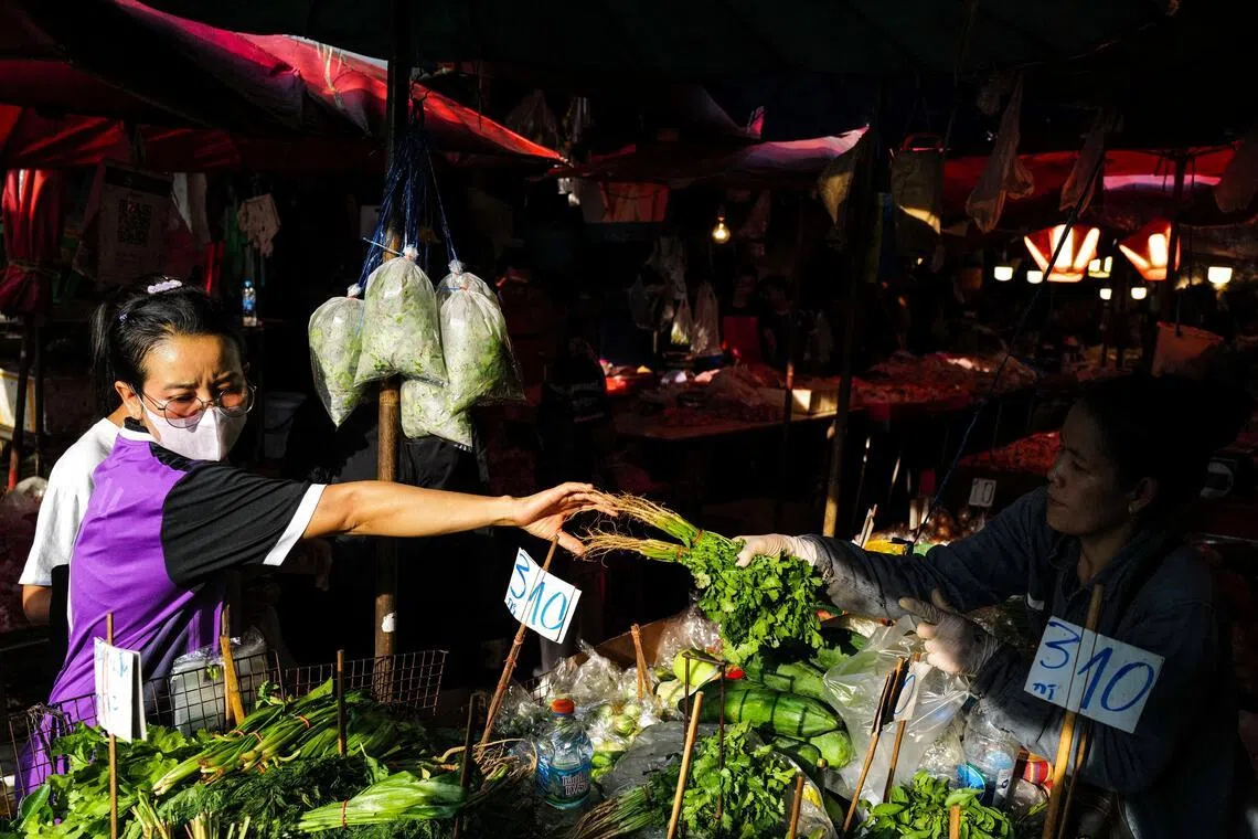 A woman buys a vegetable at a stall at a fresh market in Bangkok, Thailand, April 30, 2026. REUTERS/Athit Perawongmetha     TPX IMAGES OF THE DAY     