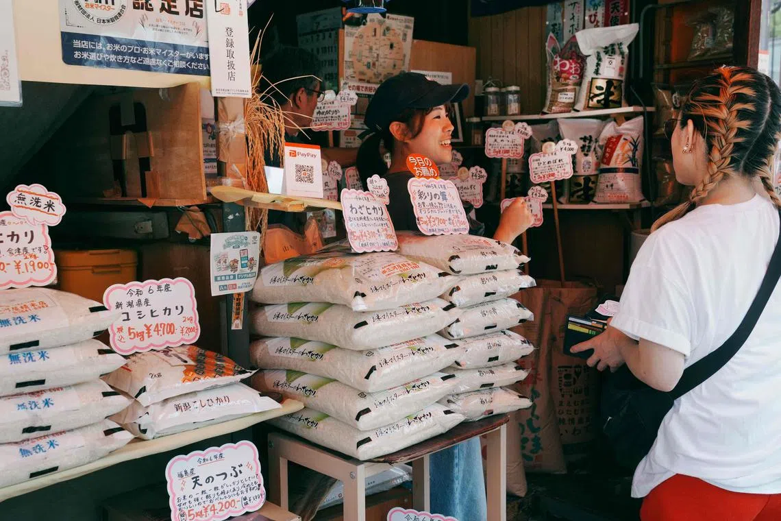 A rice mill employee serves a customer in Tokyo, Japan, July 18, 2025. Under a WTO “minimum access” framework introduced in 1995, Japan imports about 770,000 metric tons of rice tariff-free every year. Last fiscal year, the US accounted for 45 per cent of the total.