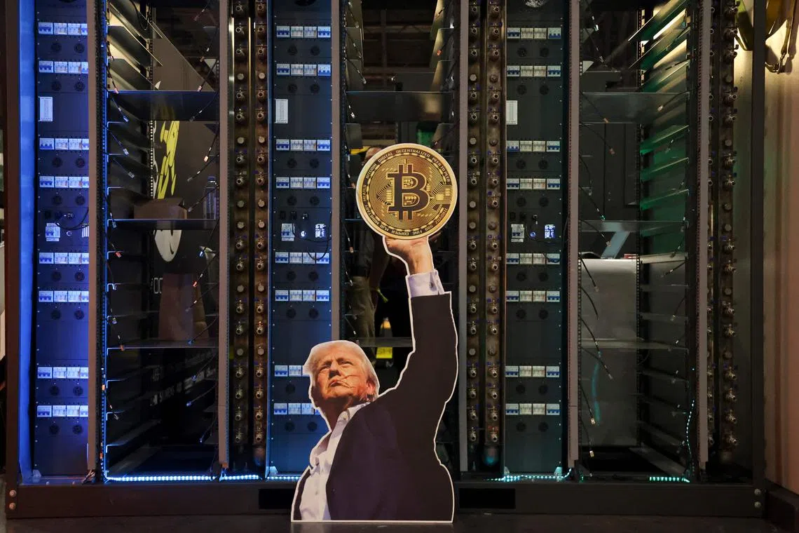 A cutout of US President Donald Trump holding a Bitcoin is displayed on a group of servers during The Bitcoin Conference at in Las Vegas in May.