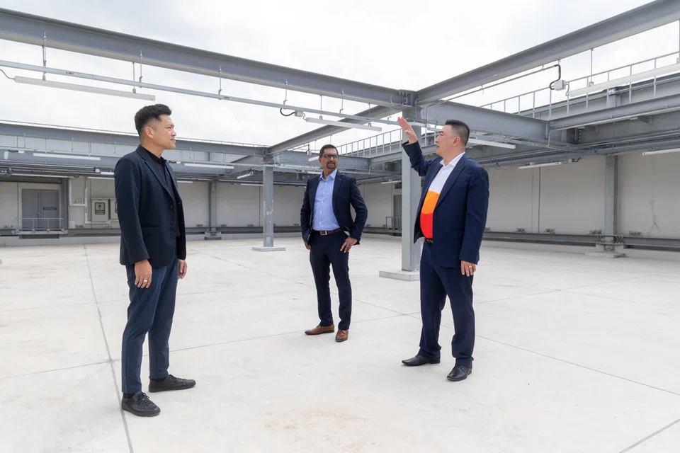 PacificLight's deputy general manager of business development, Thomas Lim (right) showing where the solar panels will be located. With him are JTC’s group director of new estates Nelson Liew (left) and Univers' director of delivery lead Zahir Siddique.