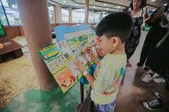 A participant completing the POSB and Mandai Super Saver Mission booklet, which blends financial literacy concepts with fun animal facts.
