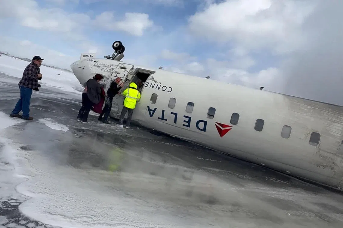 Passengers leave a Delta Air Lines CRJ-900 jet after it crashed on landing at Toronto Pearson International Airport in Mississauga, Ontario, Canada, Feb 17, 2025. Delta said 21 passengers were injured in the accident but only one was still hospitalised as of Wednesday morning. 