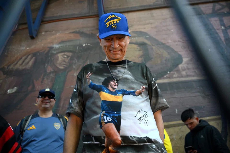 A fan wearing a Diego Maradona hat and shirt in Boca Juniors colours at the club's La Bombonera stadium in Buenos Aires on Oct 9.