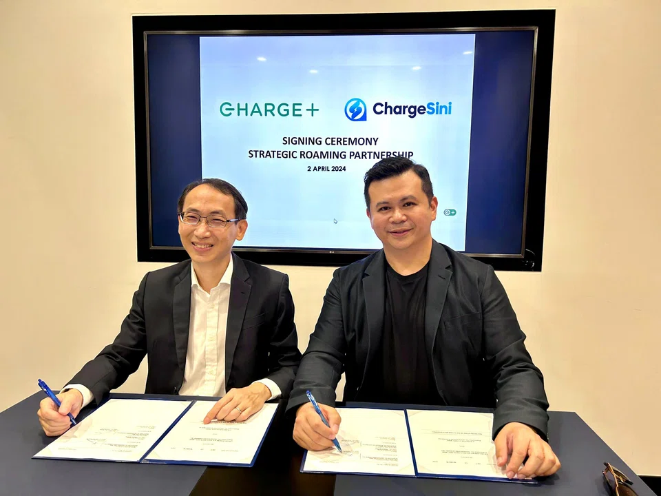 Charge+ chief executive Goh Chee Kiong (left) and ChargeSini founder and CEO James Goh signing the agreement to facilitate cross-border charging for customers of both companies. 