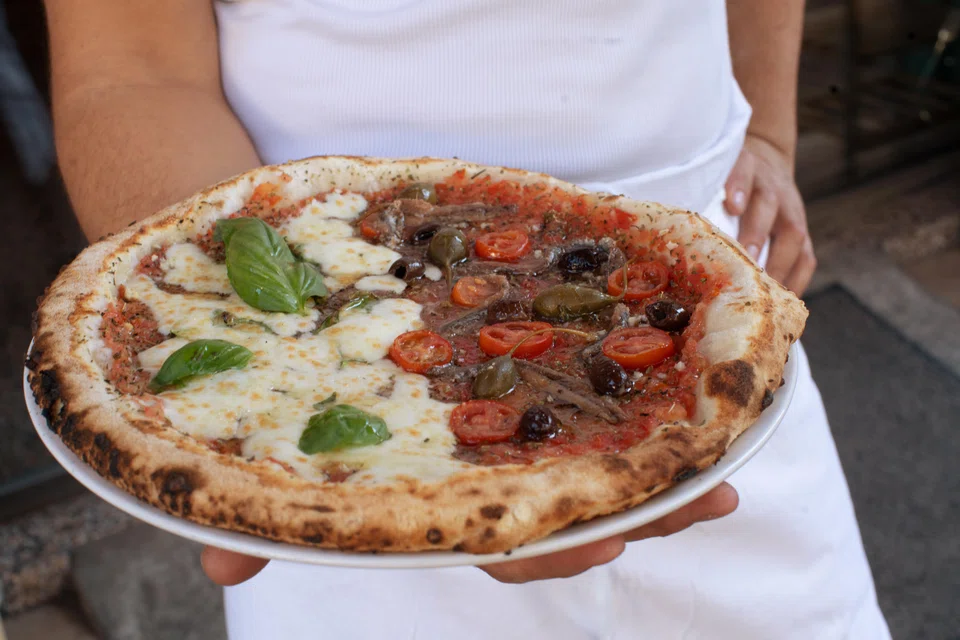 The classic Marseille slice is the moitie-moitie (half-half), a tomato-based pie with anchovies on one side and cheese on the other.