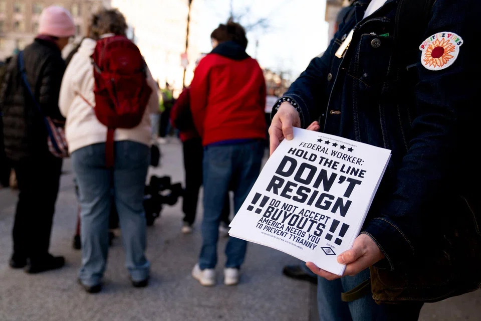 A demonstrator holds fliers encouraging federal workers not to resign during a protest against Elon Musk outside the US Treasury building in Washington, DC, Feb. 4, 2025. The US Treasury Department confirmed Tuesday that Elon Musk’s government efficiency team has been given “read-only” access to “coded data” of the government’s payments system. 