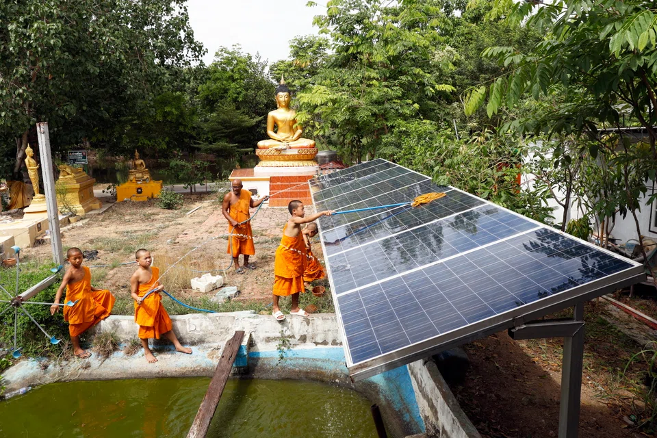 A Buddhist monk and novices cleaning solar panels at a temple in Thailand. Industry players note that displaced demand from the US could expand the domestic use of solar products and scale up intra-Asean sales.