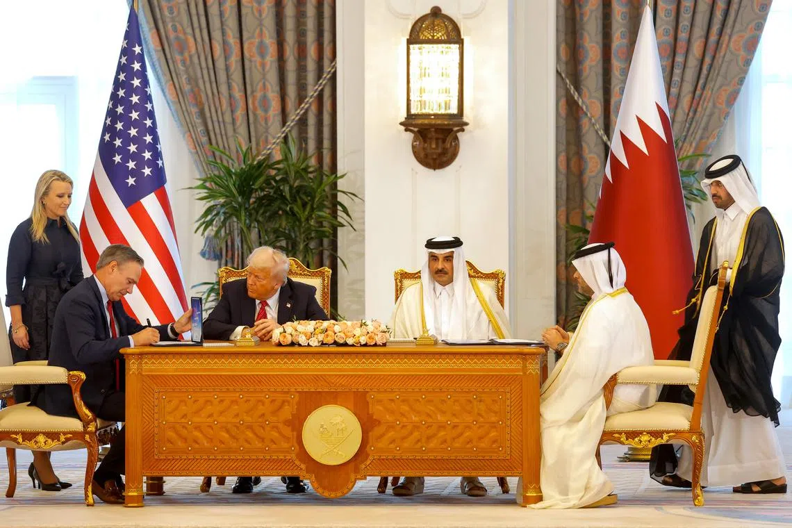 Qatar's Emir Sheikh Tamim bin Hamad al-Thani (centre right) and US President Donald Trump (centre left) watch as Boeing CEO Kelly Ortberg (left) and Qatar Airways CEO Badr Mohammed al-Meer (right) sign documents during a signing ceremony at the Royal Palace in Doha on May 14.