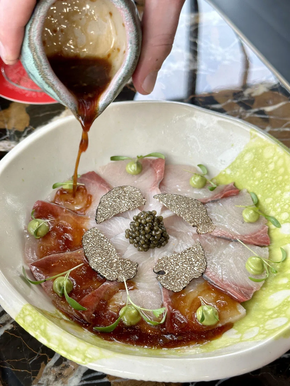 Hamachi tiradito features sliced amberjack drizzled in a citrus-soy sauce.
