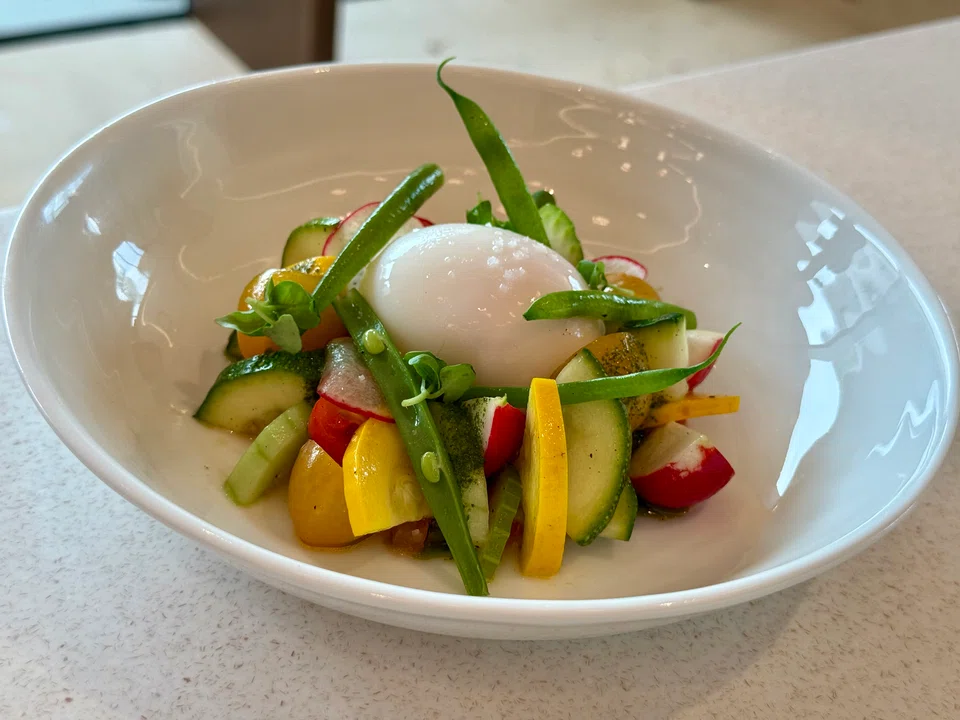 The vegetable salad sits in a refreshing crushed-tomato dressing, and is topped with a cold soft-boiled egg. 