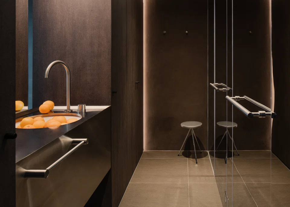 The corridor acts as a changing room with storage access, and a path to the toilet and shower area.