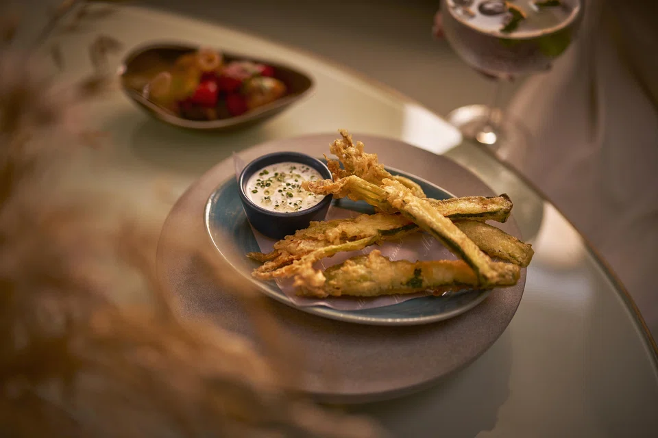 Deep-fried zucchini flowers with cottage cheese dip.