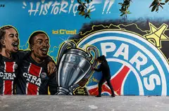 A street art mural showing PSG's Bradley Barcola and Ousmane Dembele holding the Champions League trophy after the club won the Champions League last weekend. 