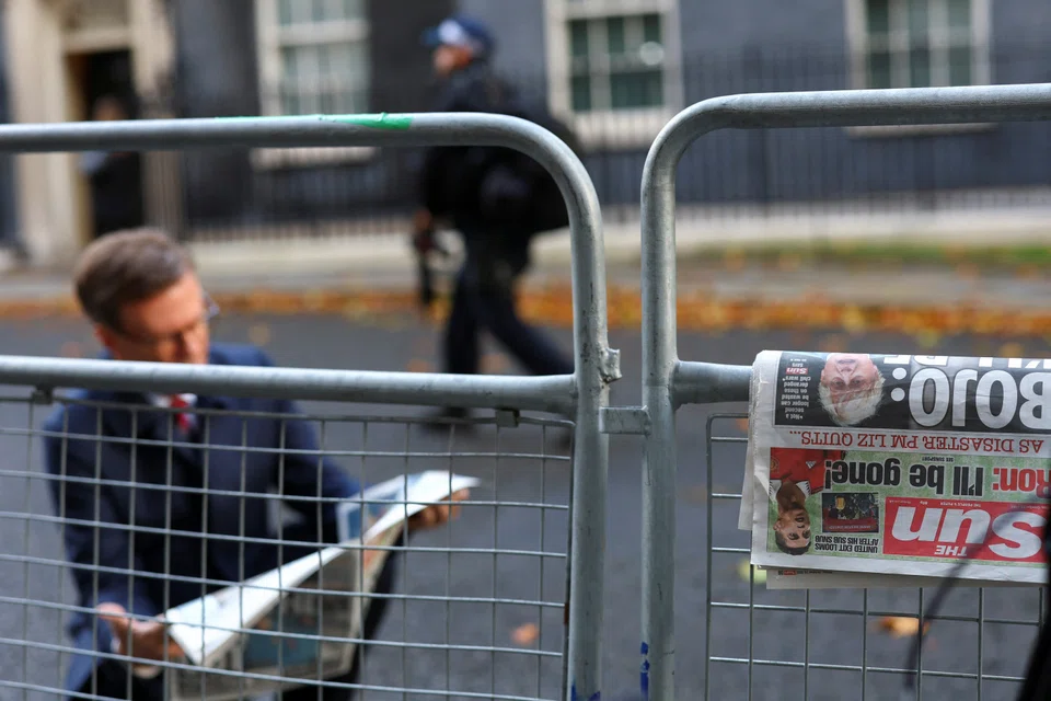 A newspaper, featuring an image of former British Prime Minister Boris Johnson, rests on a fence outside 10 Downing Street in London, October 21, 2022. 