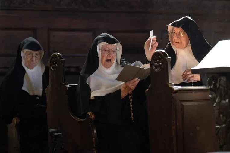 Sisters Rita (R), 81, Regina (L), 86, and Bernadette (C), 88, celebrate a mass with over a dozen of supporters and former students, at the convent chapel of the Goldenstein castle.