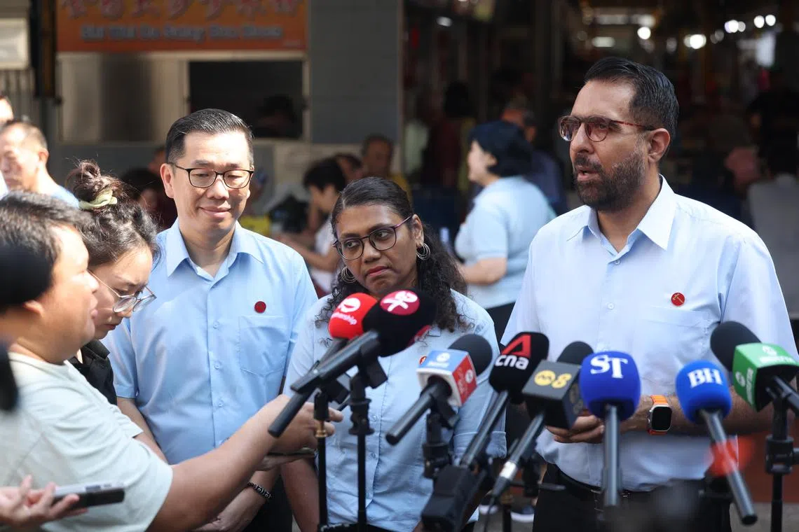 Workers' Party chief Pritam Singh (right) fields questions from reporters on the sidelines of a walkabout on Friday. Joining him were East Coast GRC candidates Jasper Kuan (left) and Paris V Parameswari (centre).