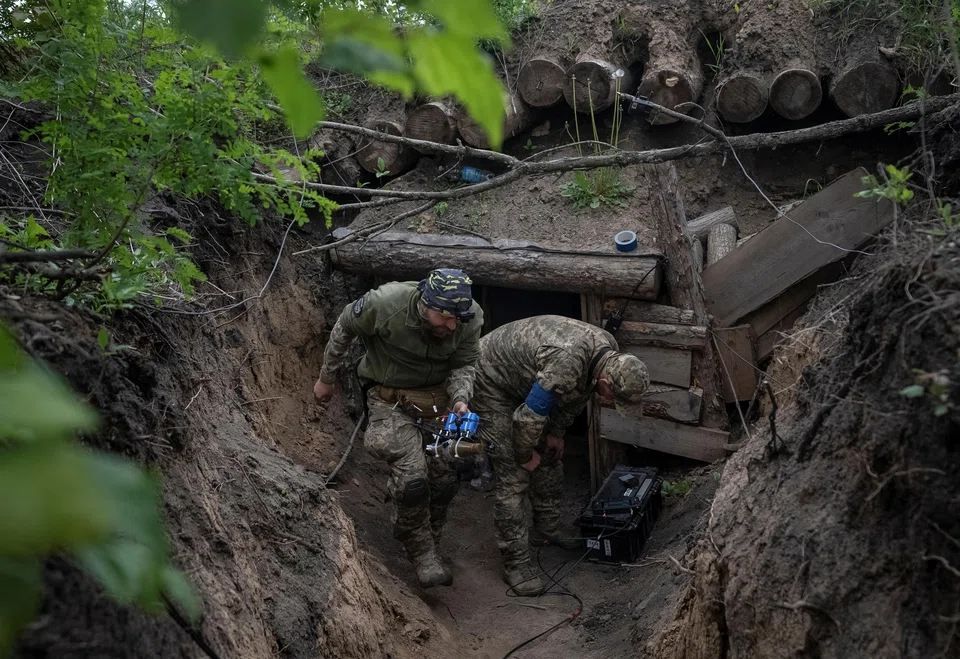 A Ukrainian serviceman carries a drone before it flies, in the Kharkiv region, May 15, 2024. 