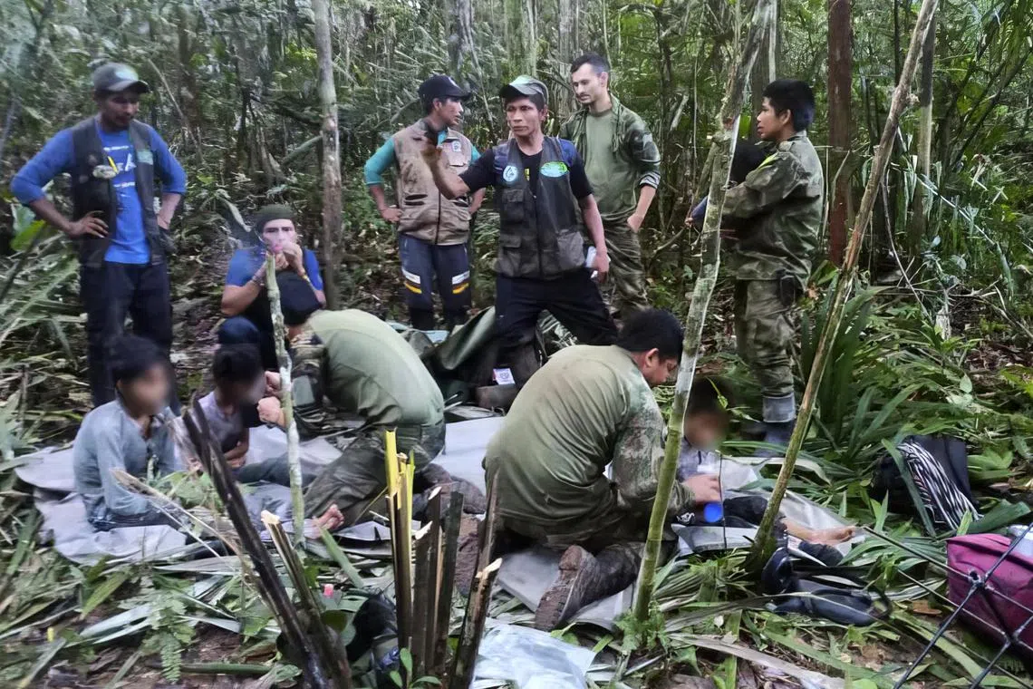 Colombian soldiers attending to the four children found alive in the Amazon jungle on June 9, 40 days after the small plane in which they were travelling crashed, killing the three adults, including their mother. 