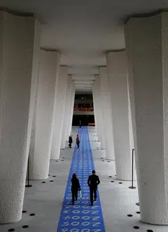 People walking along a corridor of the Governing Body at the ILO in Geneva. The job losses follow the US administration’s decision to reduce voluntary contributions.