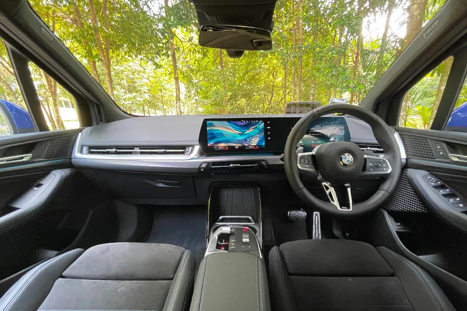 The cabin of the BMW 218i Active Tourer borrows liberally from the iX, BMW’s tech flagship. Like that car, the Active Tourer has a dashboard with a long curved screen, along with a floating armrest with a neat cluster of buttons and switches. 