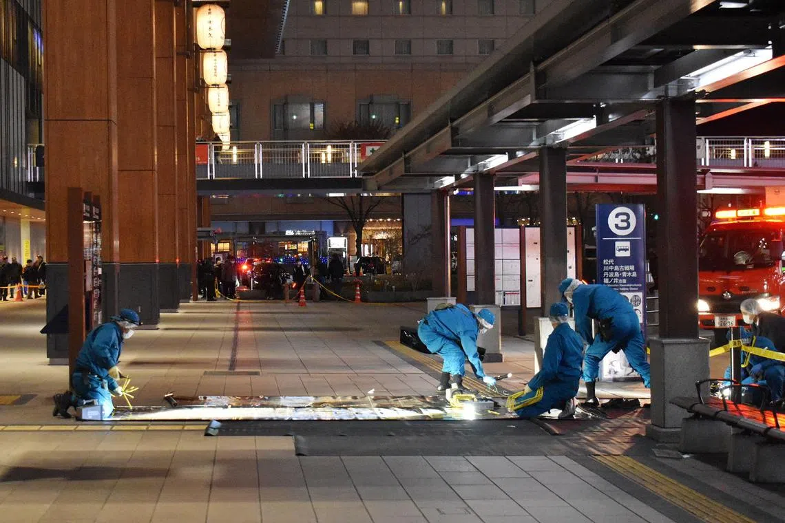 Investigators inspect the crime scene outside the JR Nagano train station after a man stabbed three people at a bus stop in Nagano, Japan, Jan 22, 2025. 
