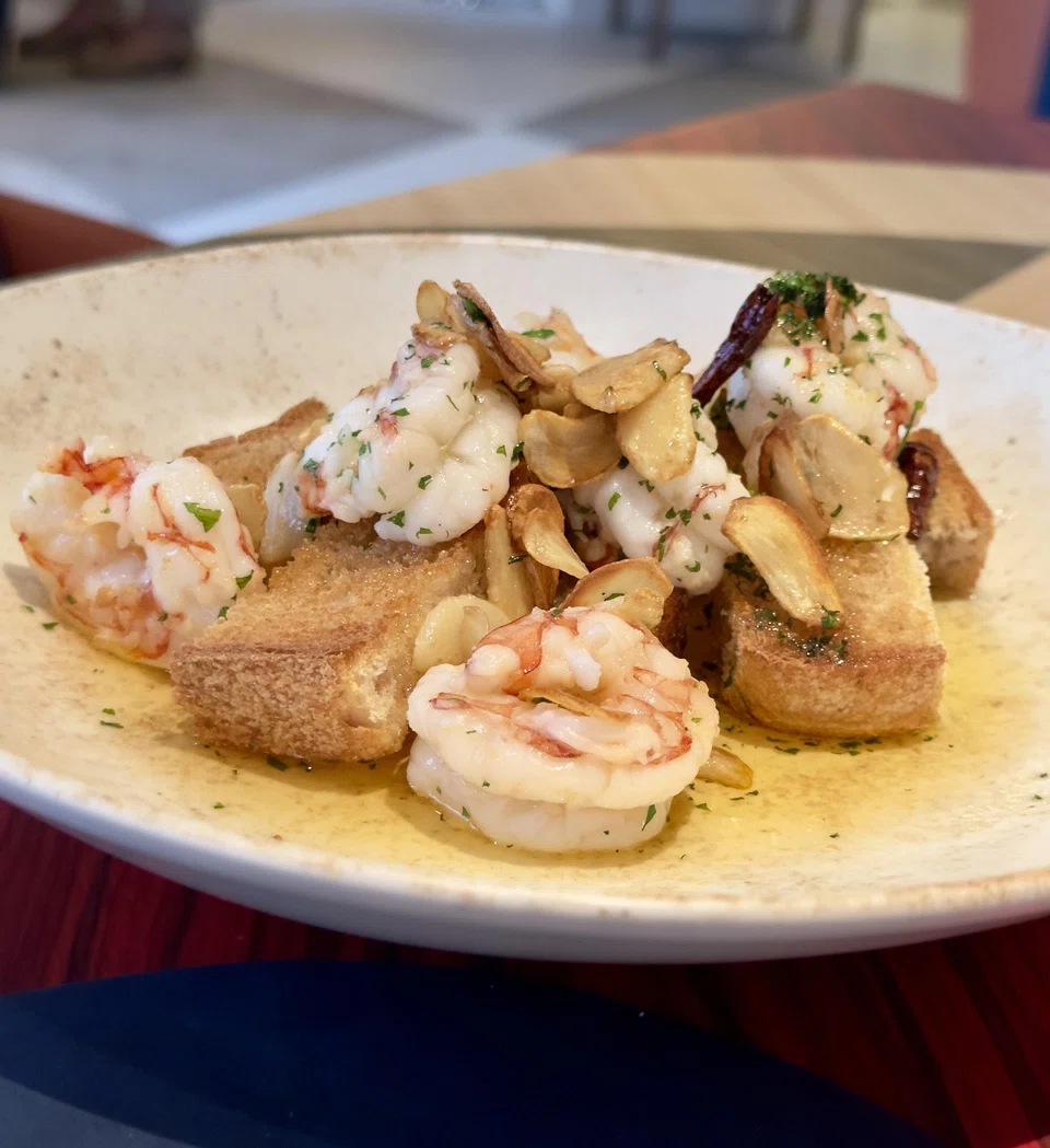 Tiger prawns served in olive oil with toasted bread.