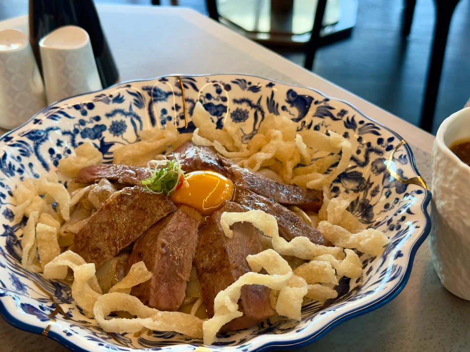 Fried hor fun topped with crispy noodles, sliced beef and egg yolk.