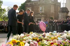 From left: Britain's Prince Harry, Duke of Sussex, his wife Meghan, Duchess of Sussex, Britain's Prince William, Prince of Wales and his wife Catherine, Princess of Wales, look at floral tributes laid by members of the public on the Long walk at Windsor Castle on Sep 10 (Saturday)  before meeting well-wishers.  Commentators said it was a show of unity that suggested that the death of the monarch could lead to a rapprochement.