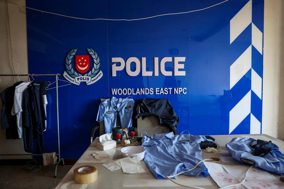 A room set up to imitate a Singapore police station, including fake Singapore police uniforms, inside a compound in O'Smach used for scam operations.