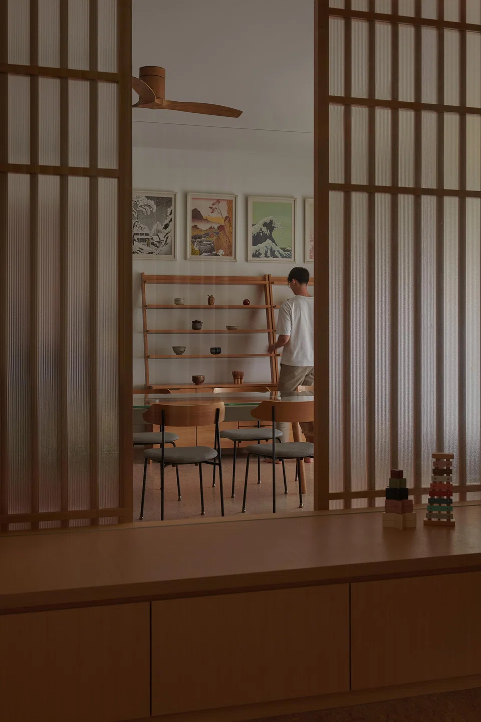 Artist duo Kozyndan's prints above Japanese ceramics in the dining area, seen from the playroom.
