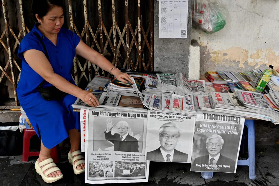 A vendor arranges newspapers reporting on the death of the general secretary of the Communist Party of Vietnam, Nguyen Phu Trong, who died on Jul 19 aged 80. 