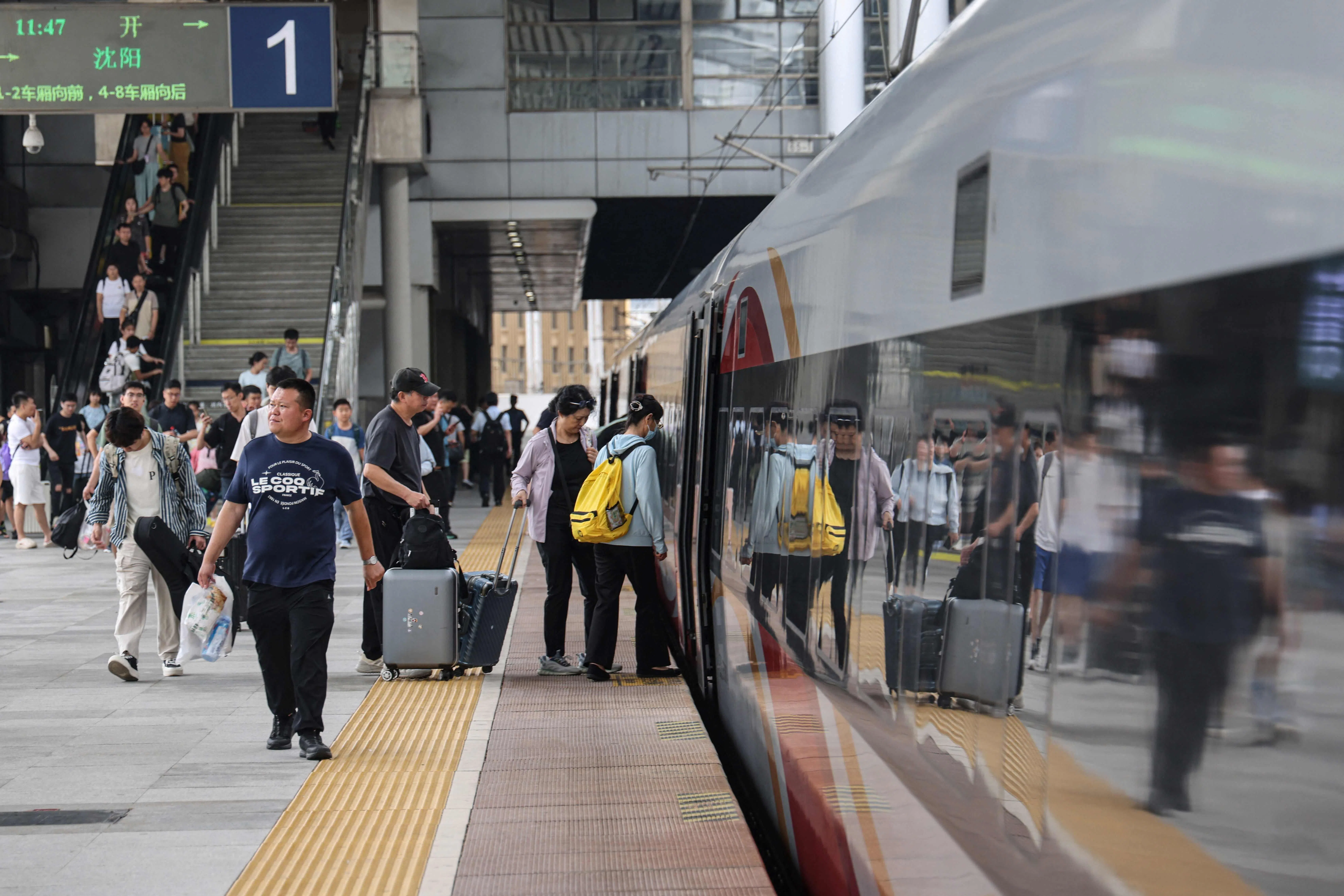 Passengers boarding a high- speed train in Dalian, in northeastern Liaoning province. In July and August, a record 943 million passenger trips were taken on China’s railways, up 4.7% year on year.