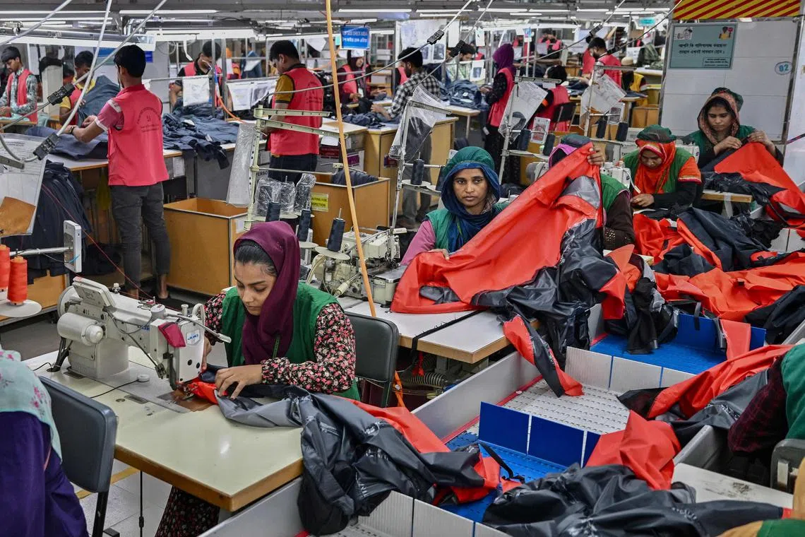 Garment workers sewing clothes at a Snowtex Group textile factory in Dhamrai, a sub-district in Dhaka, Bangladesh, Dec 29, 2024. While owners say business has bounced back, frustrated workers say hard-won concessions have done little to change their circumstances, and life remains as hard as ever.