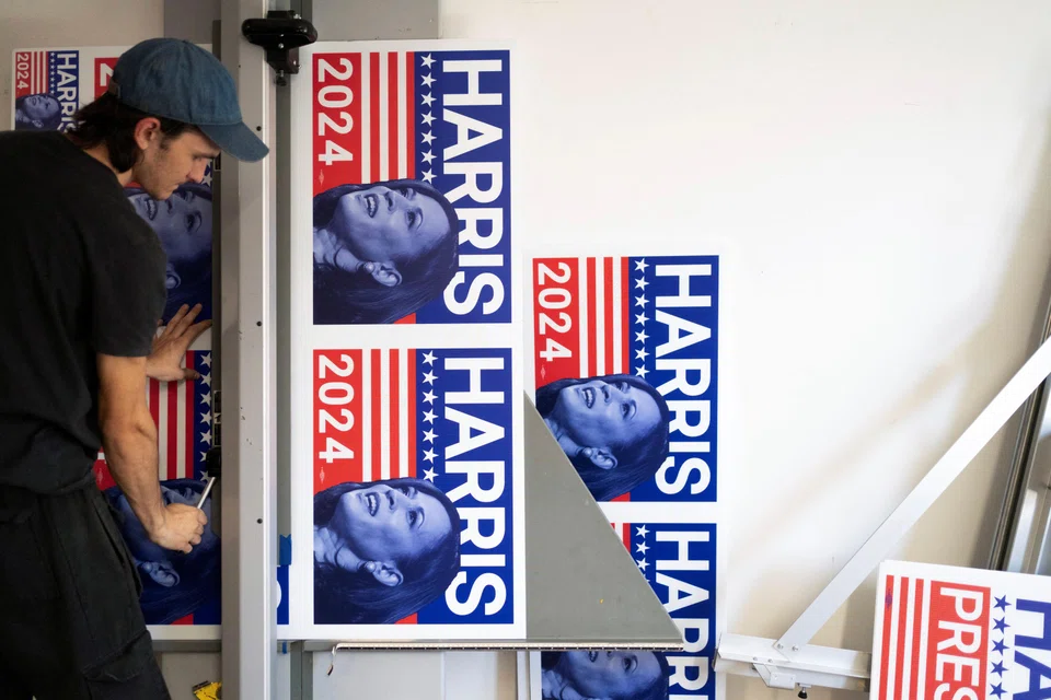 Print production specialist Aaron Miller cuts a run of 100-yard signs in support of US Vice-President Kamala Harris' presidential campaign at the Gloo Factory in Tucson, Arizona, July 25, 2024.  