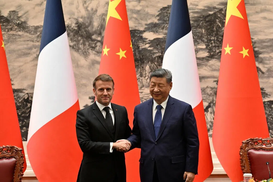 France’s President Emmanuel Macron (left) and China’s President Xi Jinping (right) shake hands after a joint press conference at the Great Hall of the People in Beijing on Dec 4.