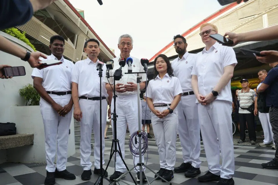 Senior Minister Lee Hsien Loong and the PAP Aljunied GRC candidates at 630 Bedok Reservoir Road Market and Food Centre on Apr 29.
